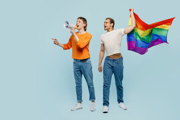Full body young couple two gay men wear casual clothes together scream in megaphone clench fist...