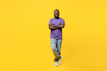 Fototapeta na wymiar Full body fun young man of African American ethnicity he wear casual clothes purple t-shirt hold hands crossed folded look camera isolated on plain yellow background studio portrait Lifestyle concept
