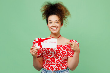 Young smiling woman she wearing casual clothes red blouse hold gift certificate point on coupon...