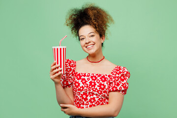 Young smiling happy fun woman she wearing casual clothes red blouse hold in hand cup of soda pop...