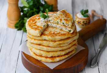 Cheese Stuffed Flatbread. Homemade Delight on Wooden Board with Sliced Flatbread. Selective Focus, horizontal, light wooden table