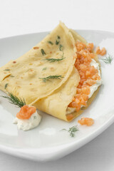 smoked salmon and sour cream crepe pancake on white background