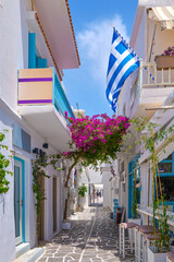 Cozy streets of Greek towns, Greek national flag, bougainvillea