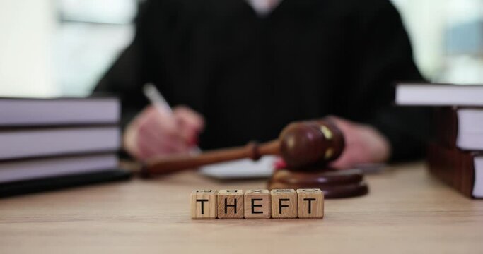 Word theft on judge table and judge gavel closeup. Thefts and examples from investigative practice