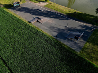 Skateboard park with concrete cement surface with concrete skateboard obstacles is designed for roller sports. Cycling is not allowed except for freestyle bikes.  winter morning sunrise, above, high