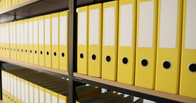 Shelf full of identical yellow office folders. Documentation archive and storage of business documents