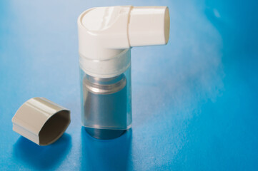 Inhaler on the blue background. Pharmaceutical products for using to treat or prevent an asthma...