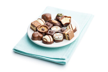 Sweet chocolate pralines.  Tasty chocolate truffles on plate isolated on white background.