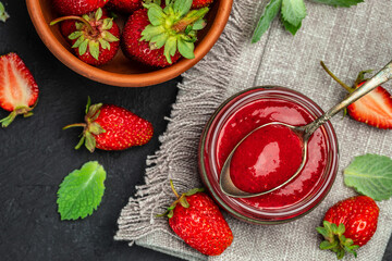 Strawberry jam in the glass jar, Homemade strawberry marmelade and fruits on a dark background. top view. place for text