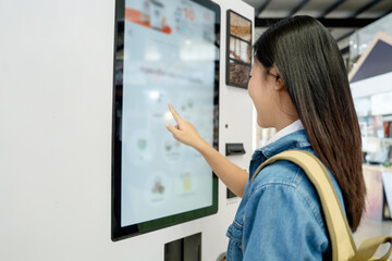 Asian female tourist choosing coffee menu from vending machine - obrazy, fototapety, plakaty