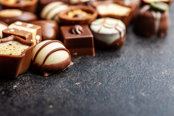 Sweet chocolate pralines.  Tasty chocolate truffles on black table.