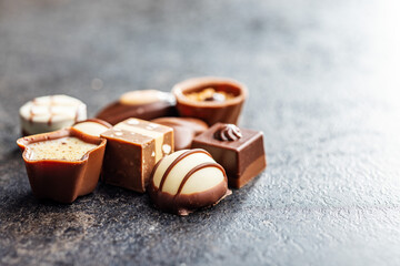 Sweet chocolate pralines.  Tasty chocolate truffles on black table.