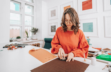 Fashion designer with brown hair printing fabric at workshop