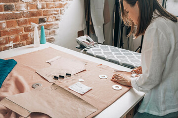 Fashion designer cutting fabric at workshop