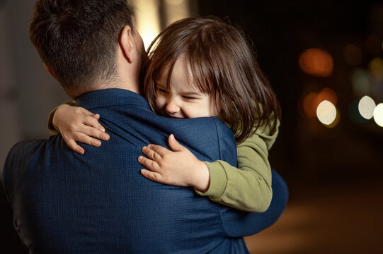 Son embracing father wearing blazer at night