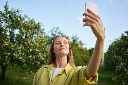 Woman taking selfie through smart phone in garden