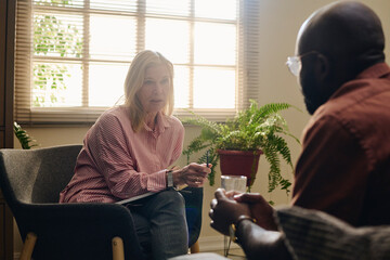 Senior psychologist advising patient in therapy session at office