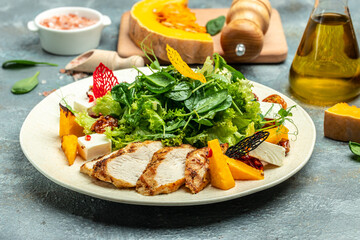 fresh salad with grilled chicken fillet, feta cheese, caramelized pumpkin, superfood keto diet concept. Healthy, clean eating, top view