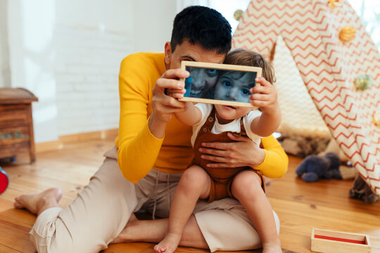 Mother and son looking through frame at home