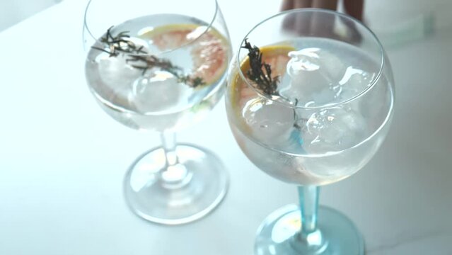 Seasoning gin and tonic cocktails with grapefruit and dried rosemary