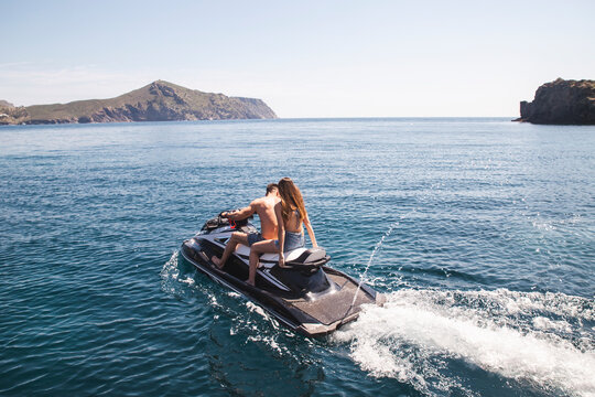 Couple sitting on jetski in water