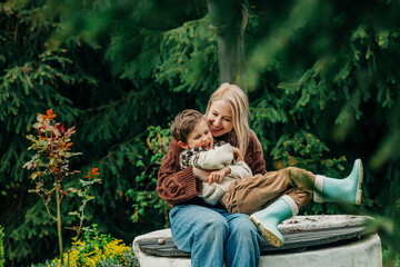 Mother with son sitting together on well in garden