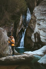 Couple in love man and woman hugging vacations outdoor romantic dating travel lifestyle relationship people enjoying waterfall view