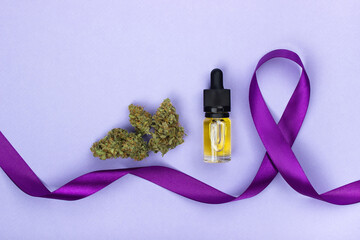 dry buds of medical marijuana  and glass bottle with CBD oil extract next to a purple epilepsy sign...