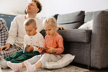 Fototapeta premium Father and his children spending time together at home