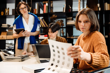 Group of architects choosing materials for interior design project in office