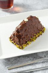 Dessert Cake from Malaga on stone table. Cake with banana inside, covered with chocolate sauce and hazelnuts