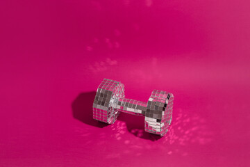 Dumbbell on magenta background. Shining bright sport. Copy space.