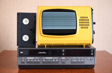 Old silver-colored TV with a VCR on the background of wallpaper.Screen noise.