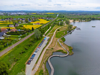 Aerial view landscape. View of the lake, paths around and fields with rapeseed. Poland, przylasek Rusiecki.