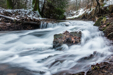 Rauschender Bach durch winterlichen Wald