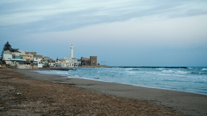 Lighthouse flashing over a big beach in Sicily coast
