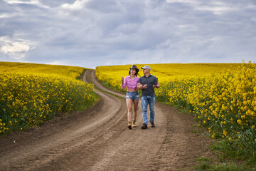 Farmers couple examining canola fields