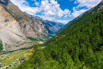 Fototapeta premium Europaweg near Zermatt in Swiss Alps. The trail leads the eye trough lush, green meadows to the distant Matterhorn. The photo was taken in sunny, summer day with clear, cloudless sky.