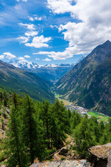 Fototapeta premium Europaweg near Zermatt in Swiss Alps. The trail leads the eye trough lush, green meadows to the distant Matterhorn. The photo was taken in sunny, summer day with clear, cloudless sky.