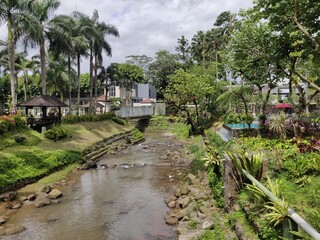 View of a small river flowing through a tropical garden in a luxury hotel