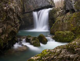 Waterfall with mossy rocks in mountain canyon in long exposure, Svrakava waterfall near Banja Luka