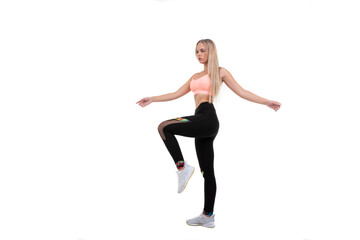 Fototapeta na wymiar Sporty beautiful blonde in a pink top, leggings and sneakers posing on a white background