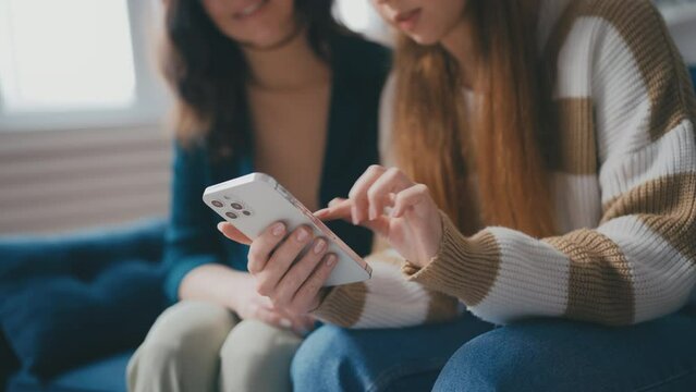Closeup of teenage girl explaining a mobile app to her mother, online shopping