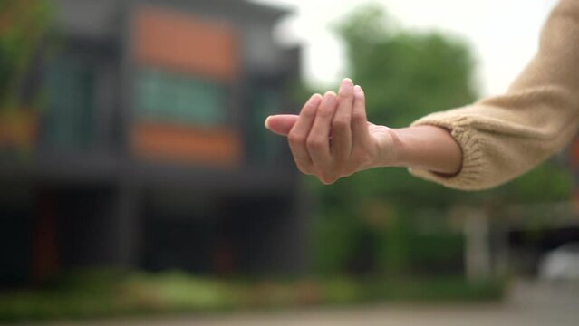 Hands of estate agent giving keys woman buying or rent new home walking to new house. First time to renter or purchase apartment, home. Moving day relocate concept.