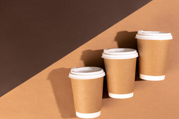 Disposable paper cups on a brown background, top view.
