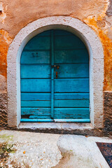 Fototapeta na wymiar Old locked blue wooden door with concrete arch, detail from the streets of Lovran, old town and travel destination in Croatia Istria