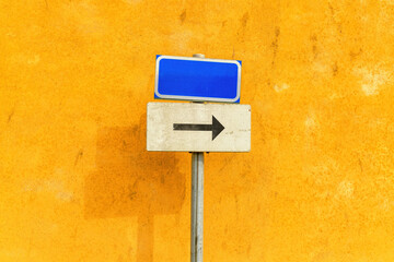 Mockup directional guide sign with arrow symbol pointing to the right against yellow wall