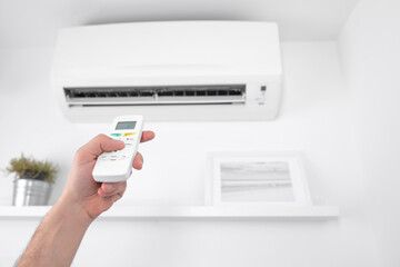 Man holding a modern AC unit remote.