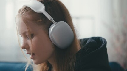 Closeup of teenage girl enjoying her favorite music in headphones, puberty phase