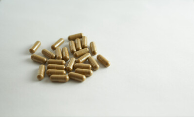 Fototapeta na wymiar Herbal capsules on a white background, selective focus.